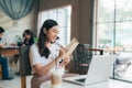 Woman hand writing journal on small notebook in cafe